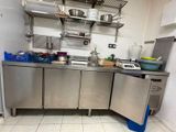 a kitchen with stainless steel cabinets and a counter with pots and pans on it