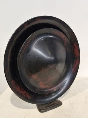 une assiette noire posée sur une table blanche