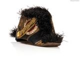 a hat with a feather on it on a white surface