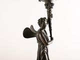 bronze statue of a woman holding a torch and a shield