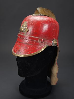 un casque rouge et doré posé sur une tête de mannequin noire