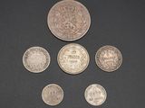 six different british coins on a black surface