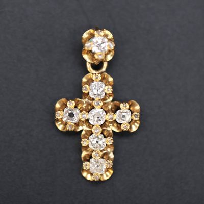 a diamond cross pendant on a black background
