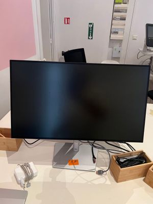 a computer monitor sitting on a desk with a keyboard and mouse