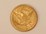 a close up of a gold coin on a white surface
