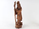 an old wooden statue of a man holding a staff