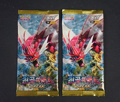 deux paquets de cartes à collectionner Pokémon posés sur une surface noire