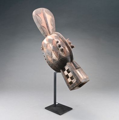 une sculpture en bois représentant un oiseau, posée sur un socle noir