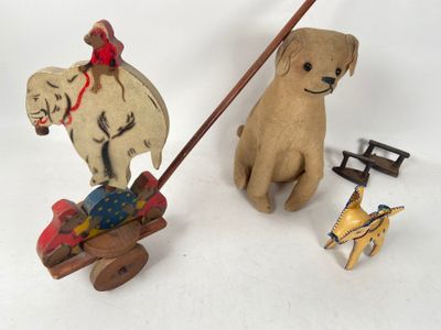 a wooden toy of a dog pulling a sleigh with a horse and a dog on it