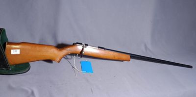 a rifle on a stand with a tag attached to it