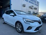 une voiture blanche garée devant un immeuble, à côté d'autres voitures