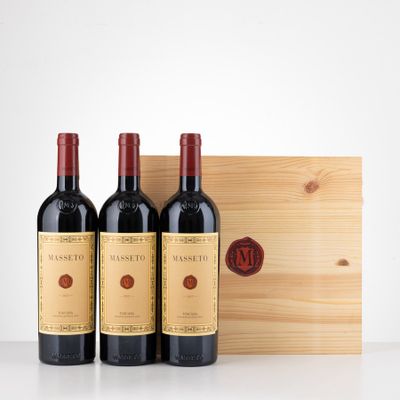 three bottles of red wine in front of a wooden box