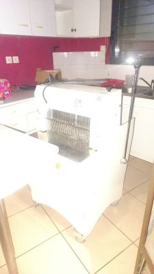 a white refrigerator in a kitchen with a red wall