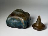 two vases sitting next to each other on a white surface