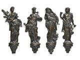 three bronze statues of women holding flowers and a bird on a pedestal
