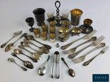 a lot of silverware on a white table