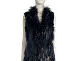the mannequin is wearing a black fur vest and black boots