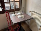 a small table with a red hand truck next to it