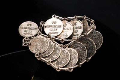 a bracelet made out of coins on a black surface