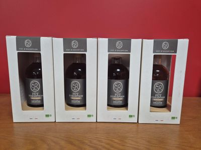 trois bouteilles de vin dans des cartons posées sur une table