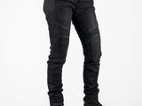 the man is wearing a black shirt and jeans and holding his hands in his pockets