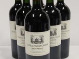 six bottles of red wine are lined up on a white surface