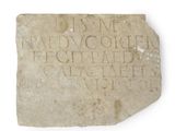 un vieux bloc de pierre portant une inscription sur une surface blanche