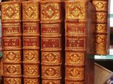 Plusieurs vieux livres sont empilés sur une étagère en verre dans un magasin