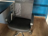 a black office chair sitting in front of a blue wall