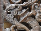 un gros plan d'une porte en bois sculpté ornée d'une horloge