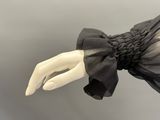 an image of a mannequin hand holding a black dress