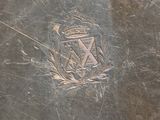 a close up of a metal plate with a coat of arms on it