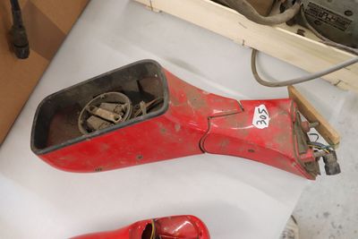 une paire de chaussures rouges posée sur une table, à côté d'une boîte à outils