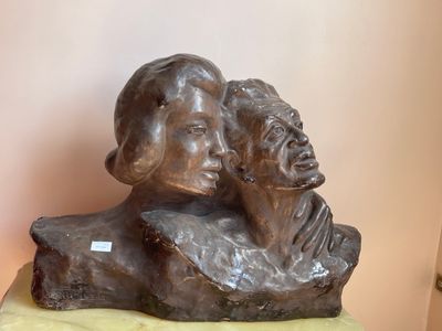 a statue of a man and a woman sitting on a rock