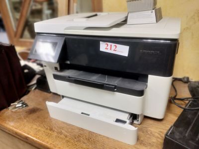 a printer sitting on top of a wooden desk next to a phone
