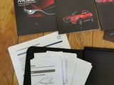 the contents of a car manual are laid out on a wooden floor