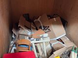 a red box full of assorted items in the corner of a room