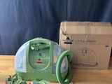 a little green vacuum sitting on a table next to a box