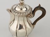 a silver tea pot with a lid and a handle