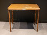 une petite table en bois sur laquelle est posé un panneau