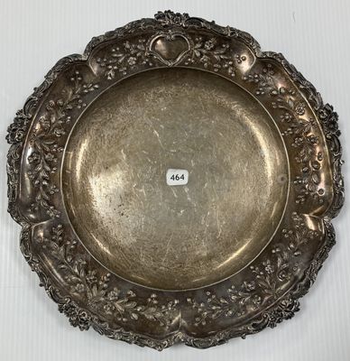 une assiette en argent posée sur une table blanche, sur laquelle figure un numéro