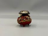 an image of a red vase with a gold dragon on it