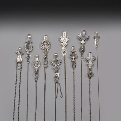beaucoup de colliers en argent posés sur une table