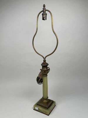 une lampe à l'ancienne avec un pied en métal et un abat-jour en verre vert
