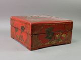a small red box with a bird design on it