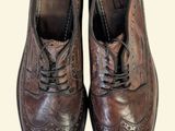 pair of brown leather shoes with laces on them on a white background