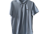 a polo shirt hanging on a hanger on a white wall