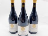 trois bouteilles de vin posées sur une surface blanche