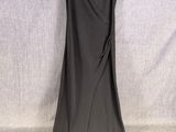 une robe noire suspendue à un cintre sur fond blanc