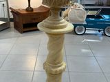 une statue représentant un oiseau, posée sur un socle dans une pièce